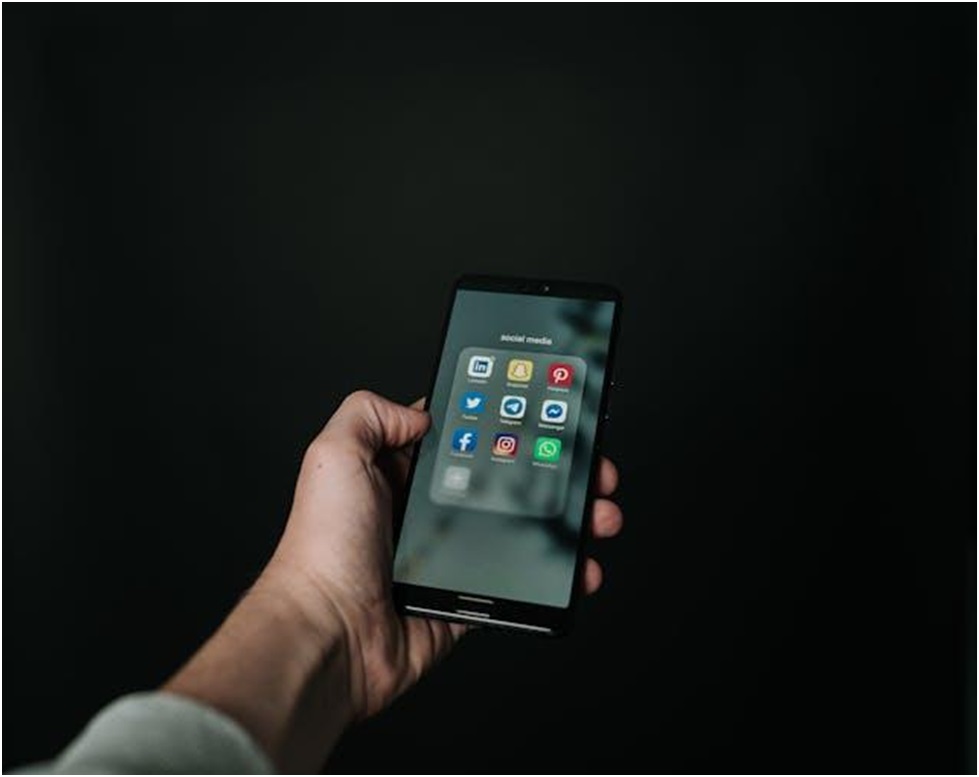 Person holding a phone showing various social media